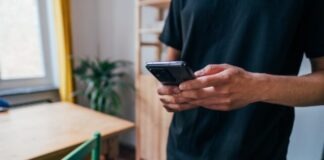 person in blue long sleeve shirt holding black smartphone