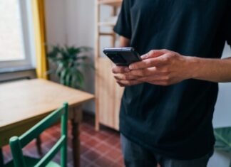 person in blue long sleeve shirt holding black smartphone