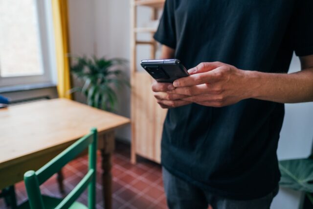 Photo by Jonas Leupe person in blue long sleeve shirt holding black smartphone