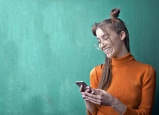 Woman in Orange Turtleneck Sweater Holding Black Smartphone