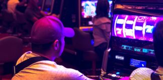 man in white t-shirt playing arcade game
