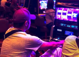 man in white t-shirt playing arcade game