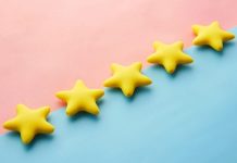 Attica’s Showdown with Fake Reviews Yellow stars on pink and blue pastel background for rating or review concept.
