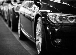 How Weather and Climate Impact Your Car’s Exterior – And How Ceramic Coating Helps Close-up black and white image of a luxury car line-up focusing on vehicle headlights.
