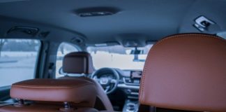 the inside of a vehicle with a brown leather seat