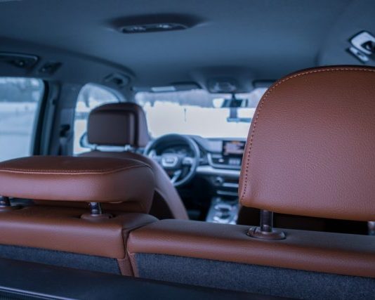 the inside of a vehicle with a brown leather seat