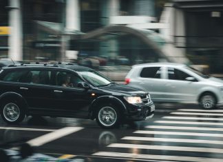 Maximizing Your Compensation After a Car Crash Vehicles speeding through a city street with a visible zebra crossing and blurred motion effect.