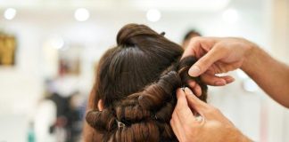 Close-up of a stylist crafting an intricate updo hairstyle in a modern salon.
