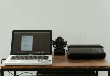 What to Do When Printer Ink Dries Out A creative home office setup featuring a laptop, printer, and artistic design work.