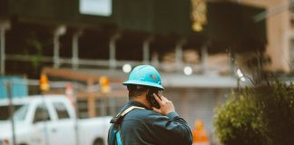 man in blue jacket wearing orange helmet
