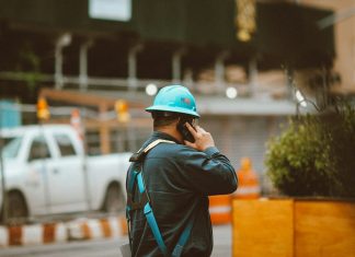man in blue jacket wearing orange helmet