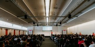 men and women sitting on chairs inside room