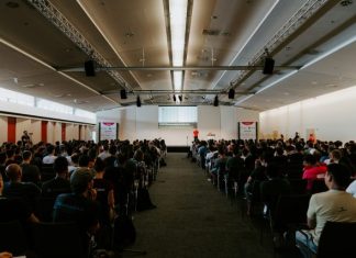 men and women sitting on chairs inside room