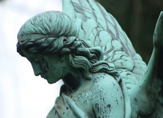 angel statue in grayscale photography