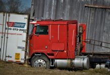 red and white freight truck on green grass field during daytime