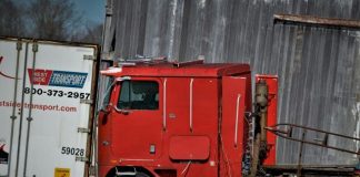 red and white freight truck on green grass field during daytime