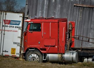 red and white freight truck on green grass field during daytime
