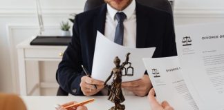 Legal professionals reviewing divorce documents in a law office with a Lady Justice statue.