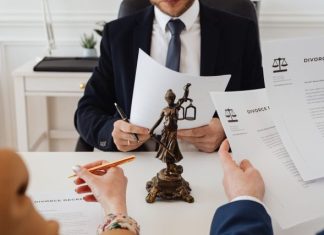 Why Most Personal Injury Lawyers Work on Contingency Legal professionals reviewing divorce documents in a law office with a Lady Justice statue.
