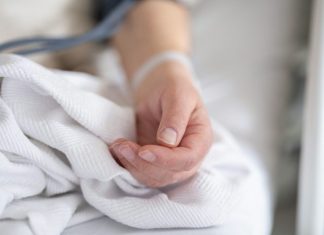 How Are Wrongful Death Suits Determined? a person with a bandage on their hand sitting on a bed