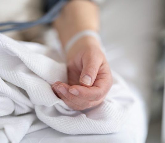 How Are Wrongful Death Suits Determined? a person with a bandage on their hand sitting on a bed