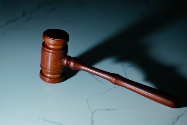 Photo by Wesley Tingey a wooden judge's hammer sitting on top of a table